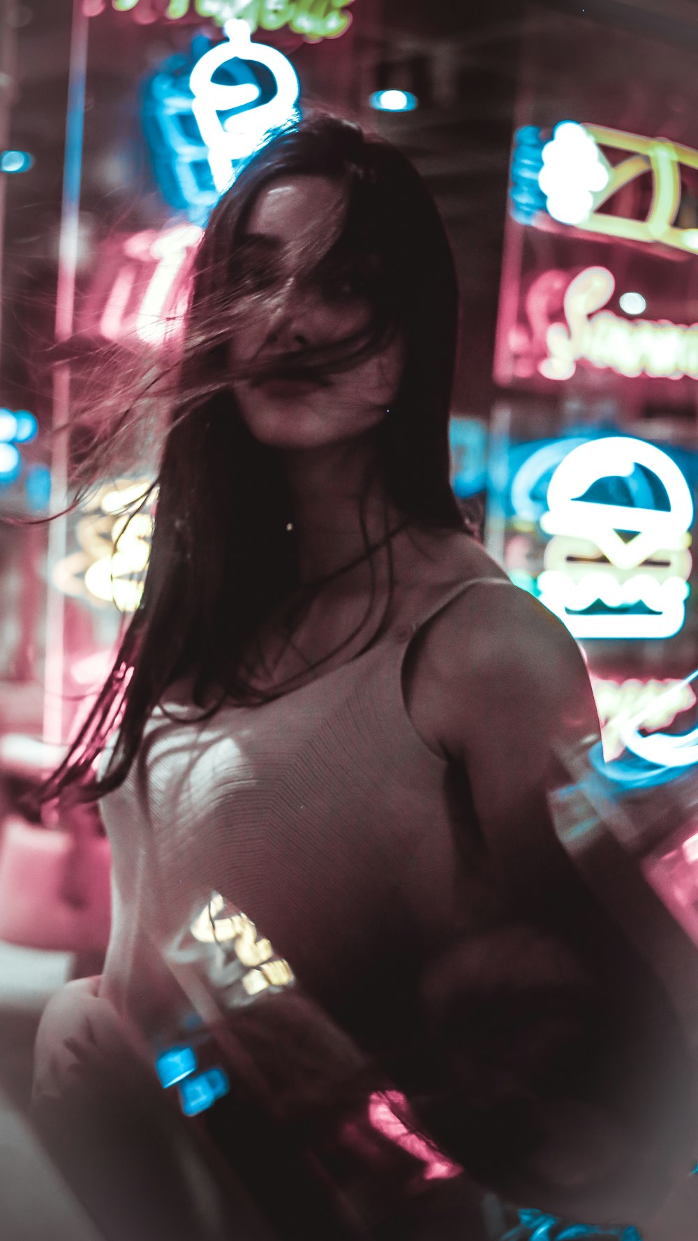 a woman standing in front of neon signs