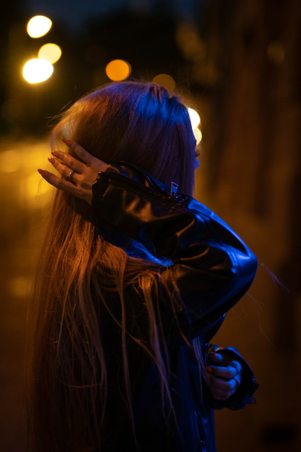 woman in blue jacket covering her face with her hair
