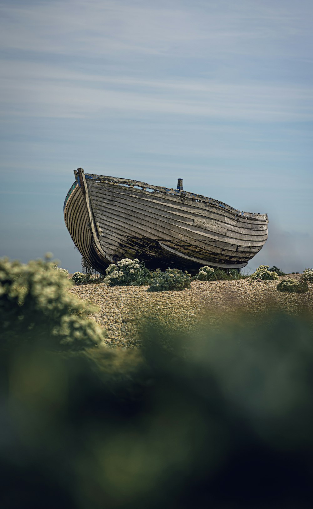 a boat sitting on top of a sandy beach