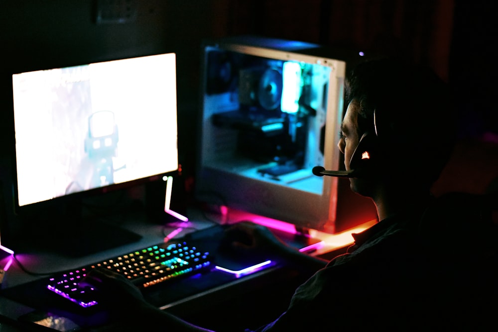 a person wearing a mask sitting in front of a computer
