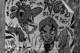 A black and white poster featuring cartoon-style characters. One character is performing with a microphone, while another has a wild hairstyle and oversized accessories. Text on the poster advertises a live band and mentions a show from 8 PM to 12 AM. The phrase 'Ready or Not!' and 'Mask Required' are prominent, along with large stylized letters 'WGI'.