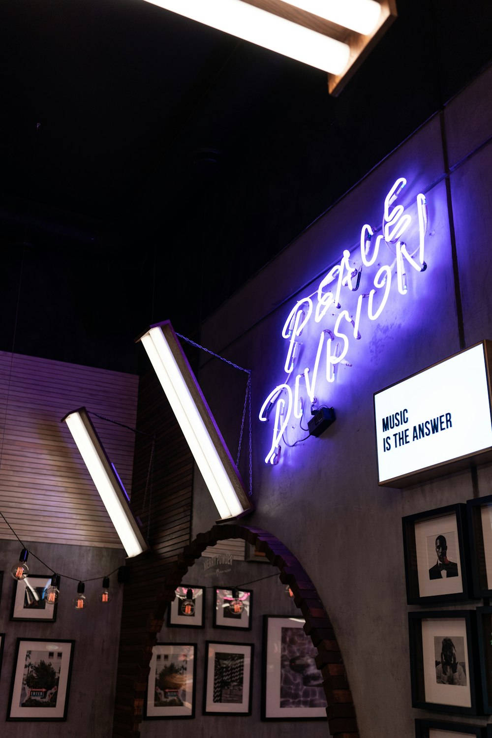 a purple neon sign hanging from the side of a wall