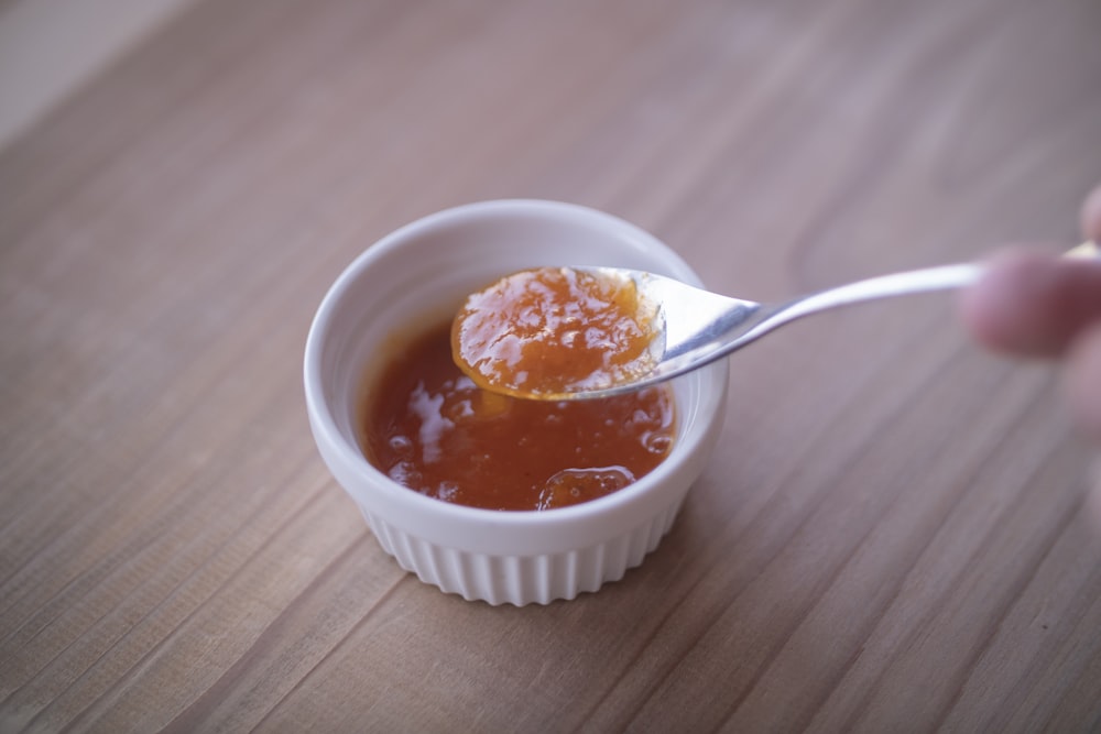 a person is spooning honey into a small bowl