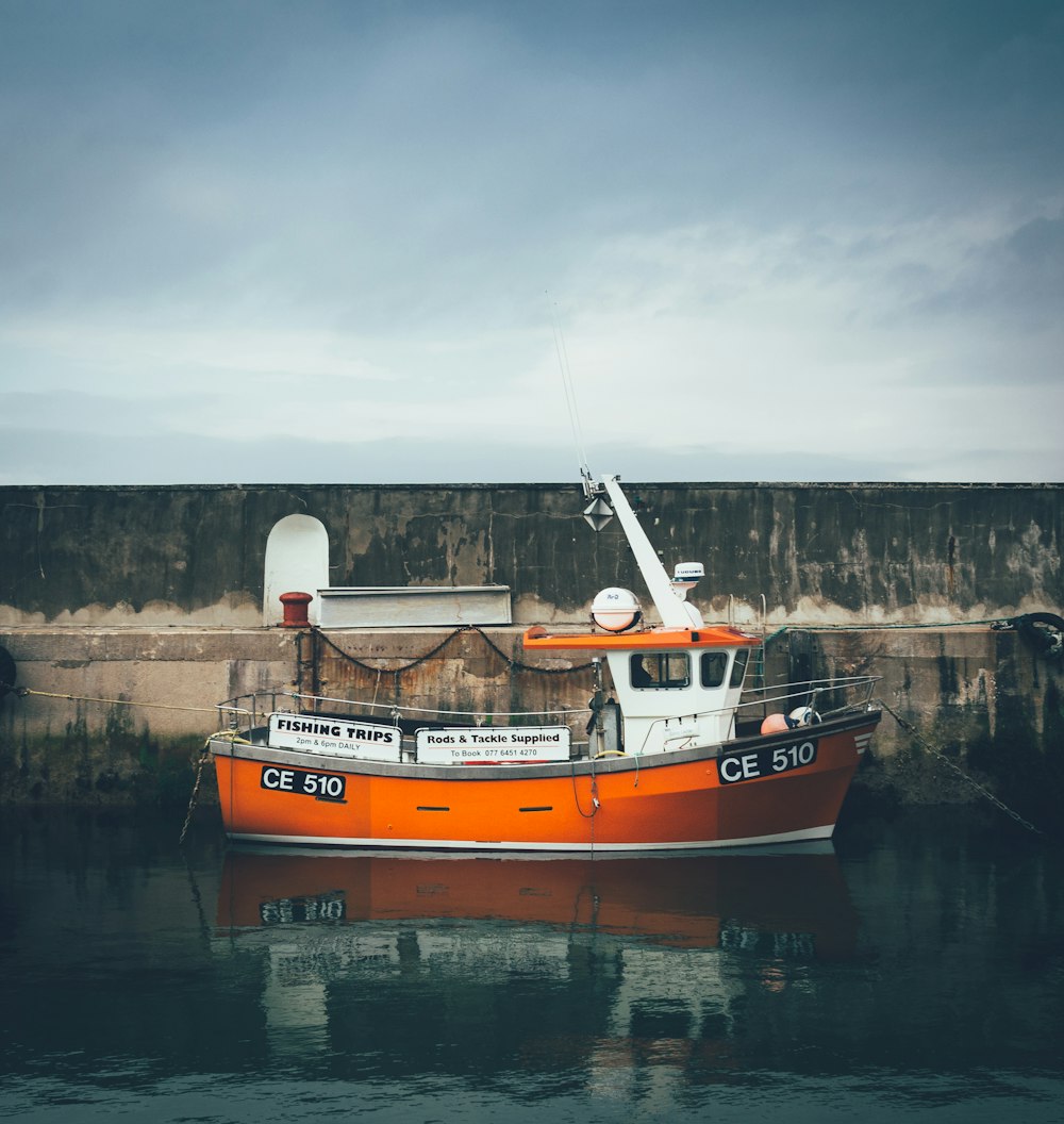 an orange and white boat in a body of water