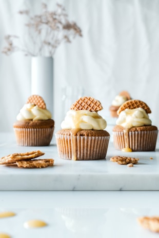 a table topped with cupcakes covered in frosting
