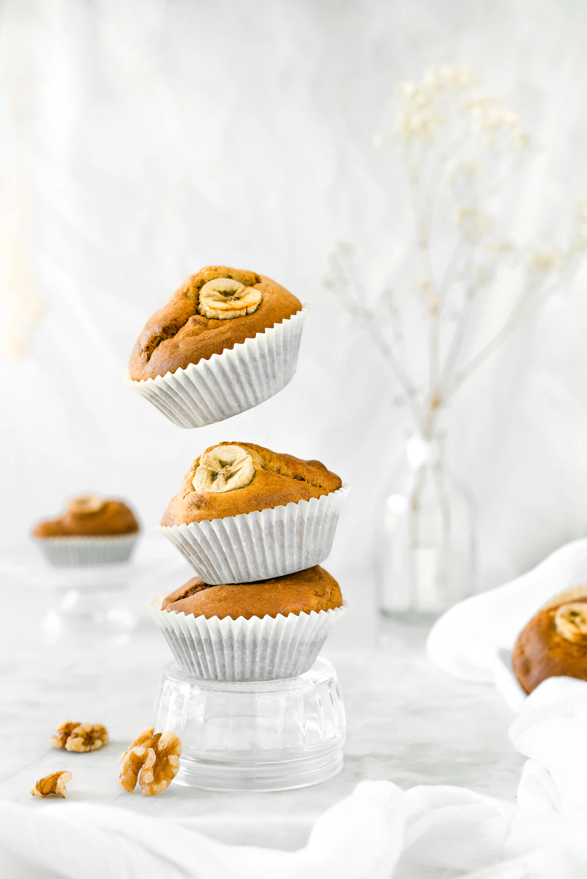 Tumpukan tiga muffin homemade berukuran mini di atas piring putih sebagai ilustrasi energy ball dan banana muffin sehat untuk bekal anak TK dengan bahan pisang dan oats