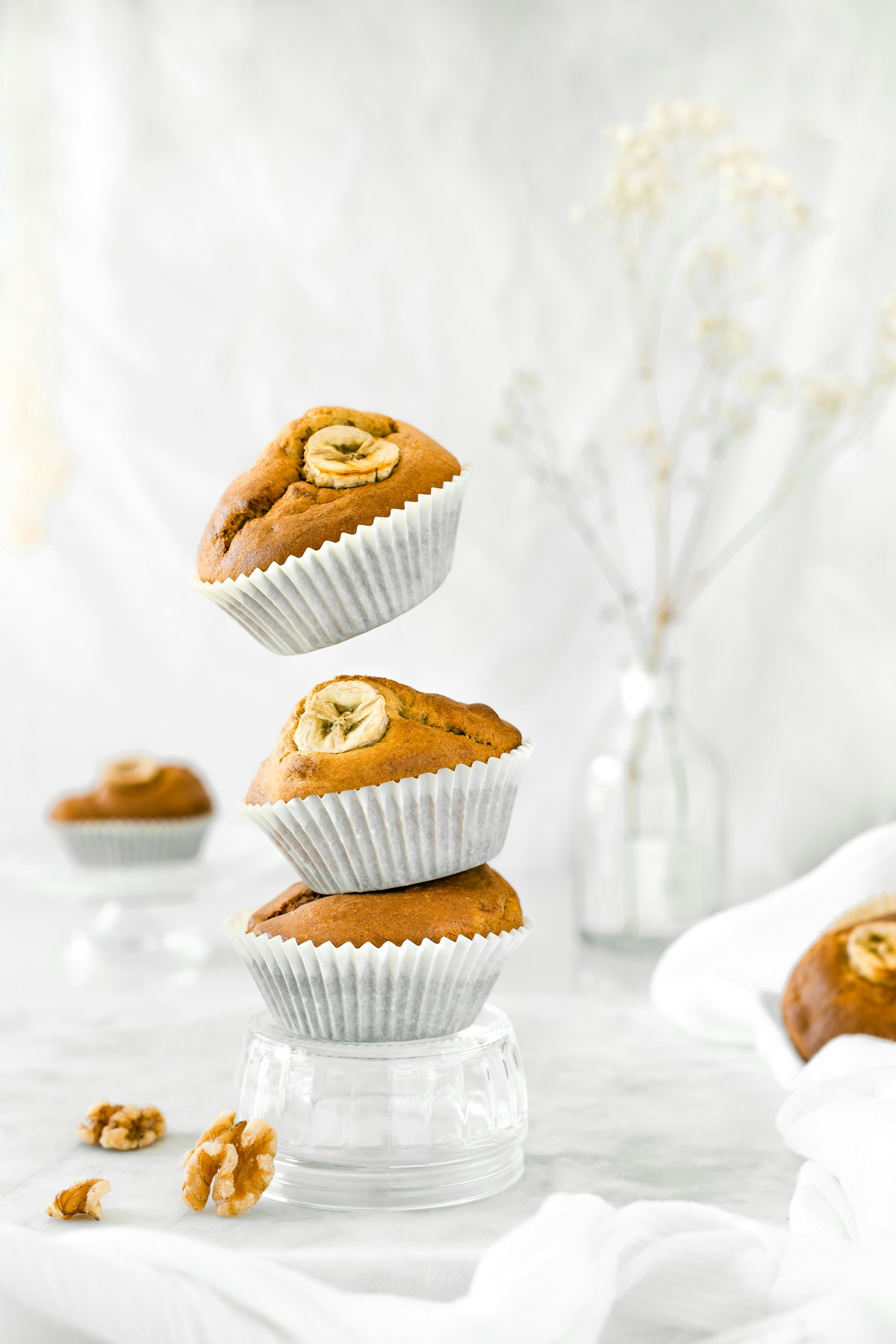 Tumpukan tiga muffin homemade berukuran mini di atas piring putih sebagai ilustrasi energy ball dan banana muffin sehat untuk bekal anak TK dengan bahan pisang dan oats