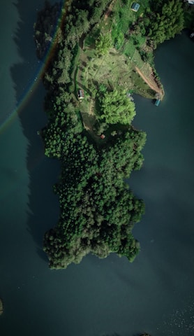 an aerial view of a lake with a rainbow in the sky