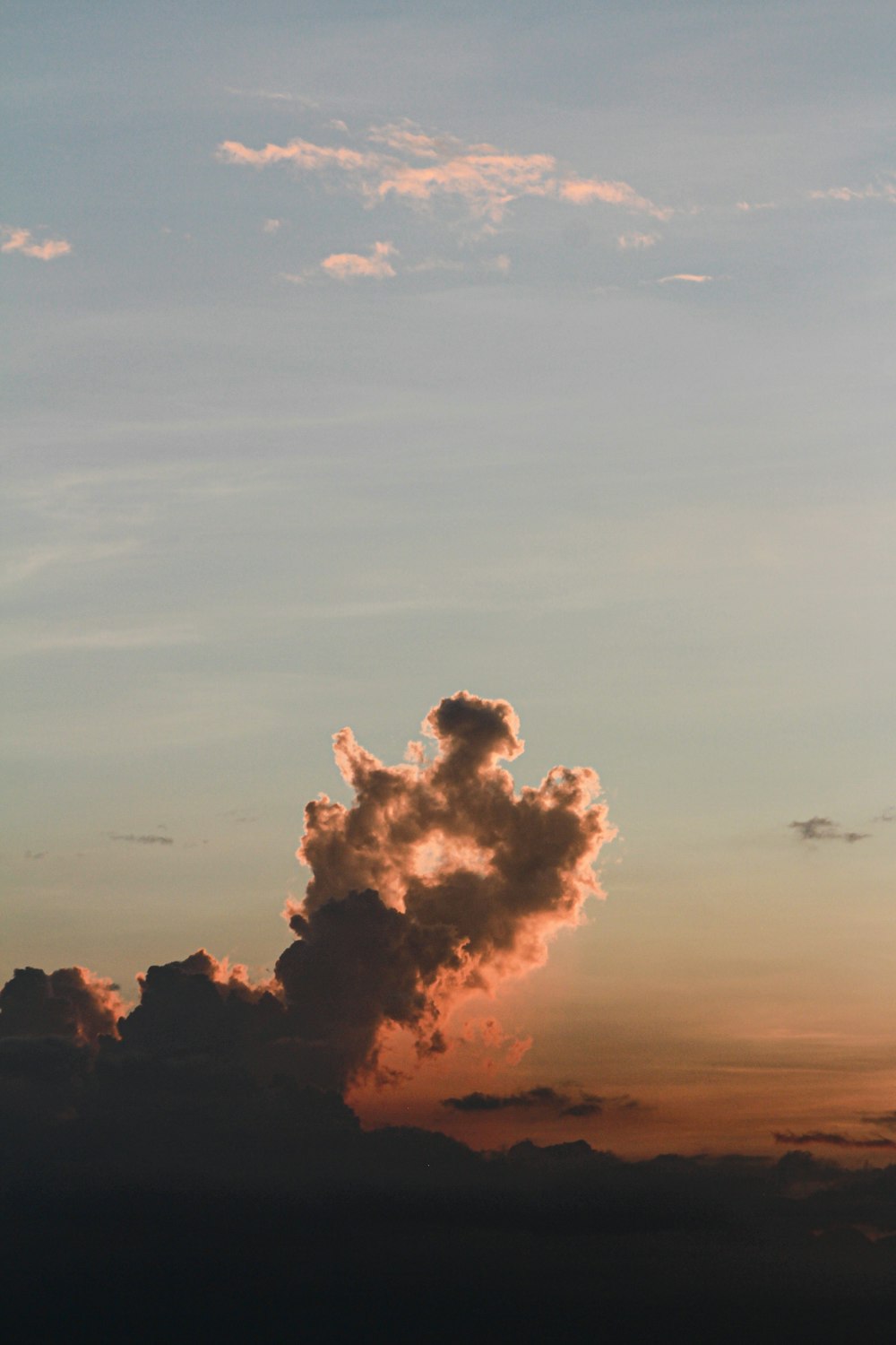 a plane flying in the sky at sunset