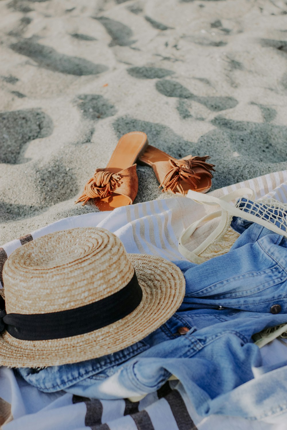 a pair of sandals and a hat laying on a towel