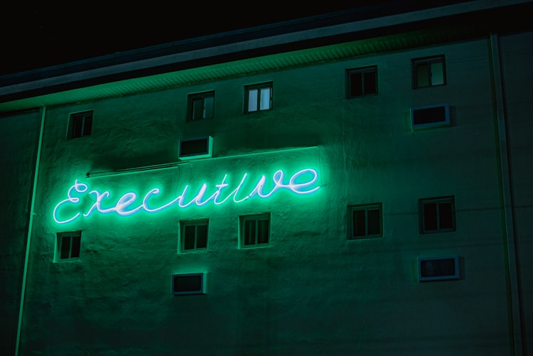 Neon sign with "executive" on side of building
