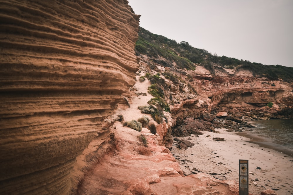 a beach with a cliff and a body of water