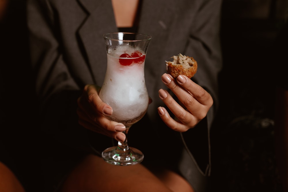 a woman holding a drink and a pastry