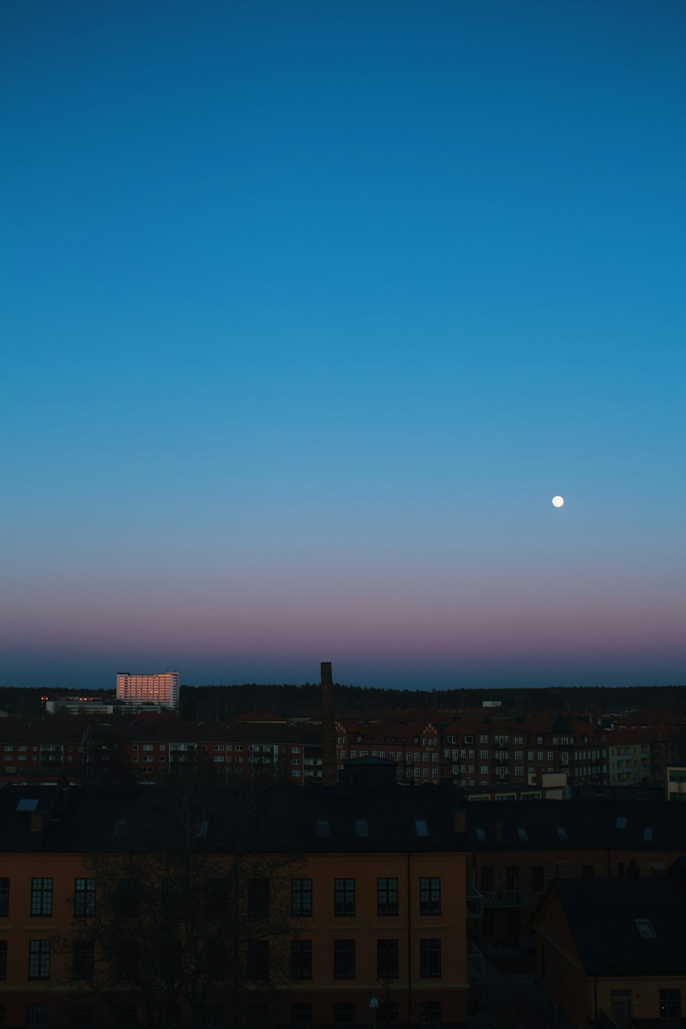 a full moon is seen in the sky over a city