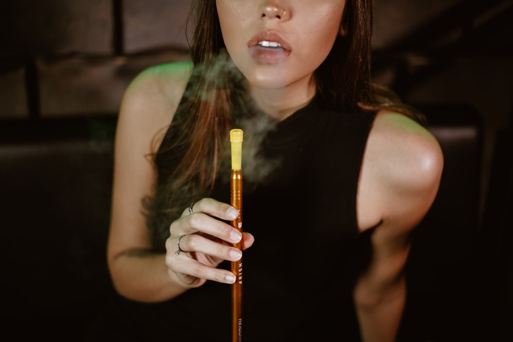 a woman smoking a cigarette in a dark room