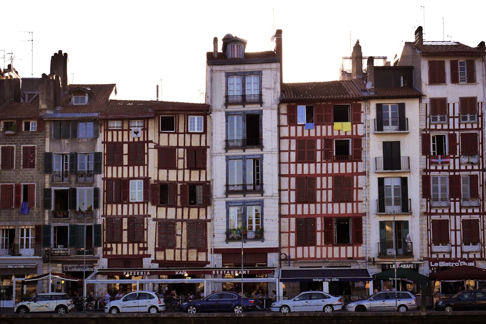 a row of buildings with cars parked in front of them