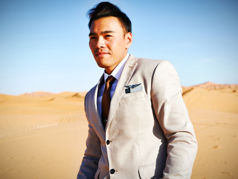 Un uomo in giacca e cravatta in piedi nel deserto