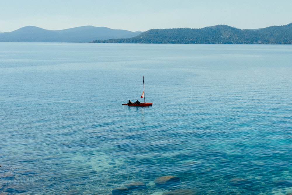 a small boat floating on top of a large body of water