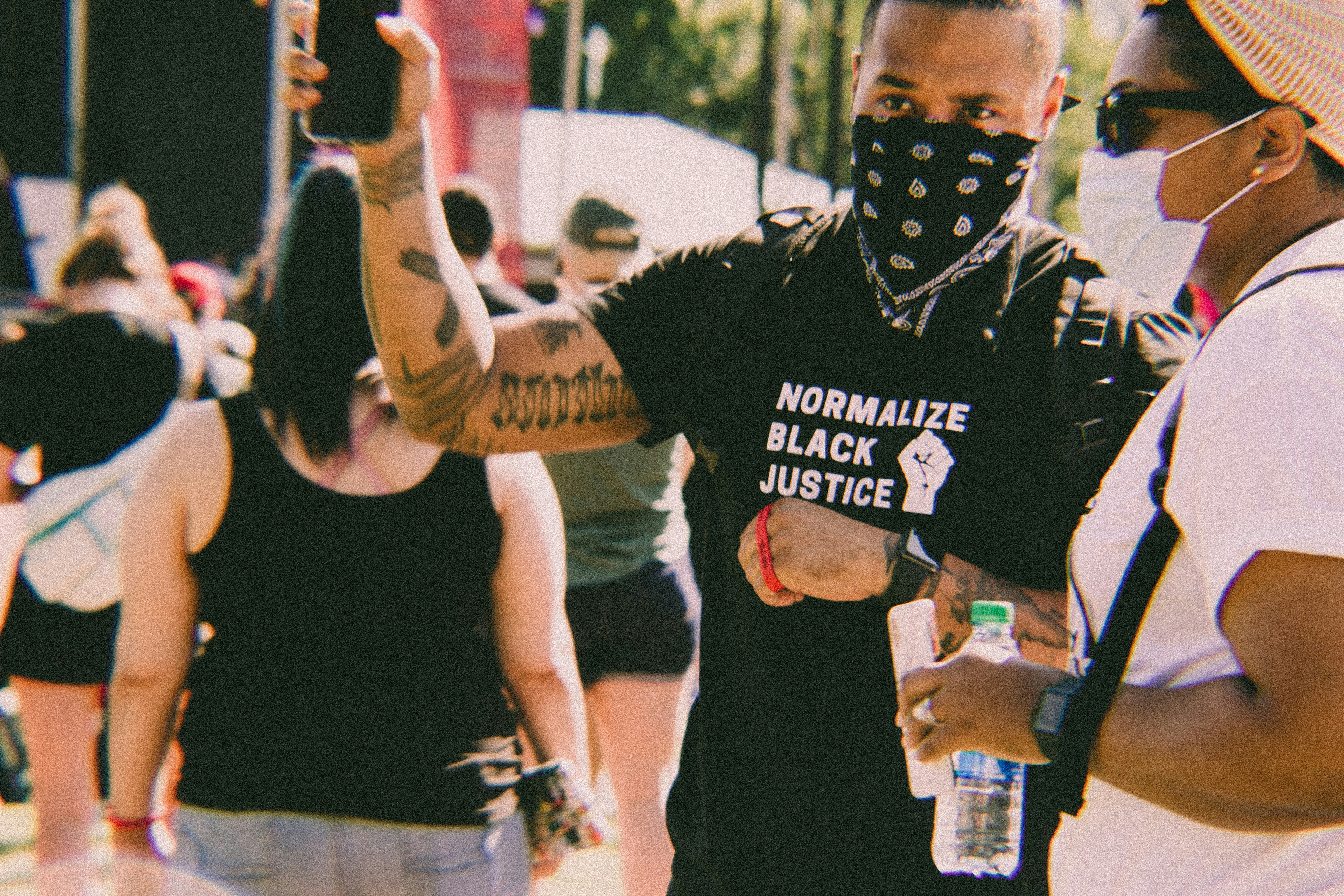 a man wearing a face mask and holding a cell phone, 