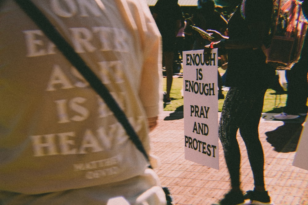 a group of people standing around each other holding signs