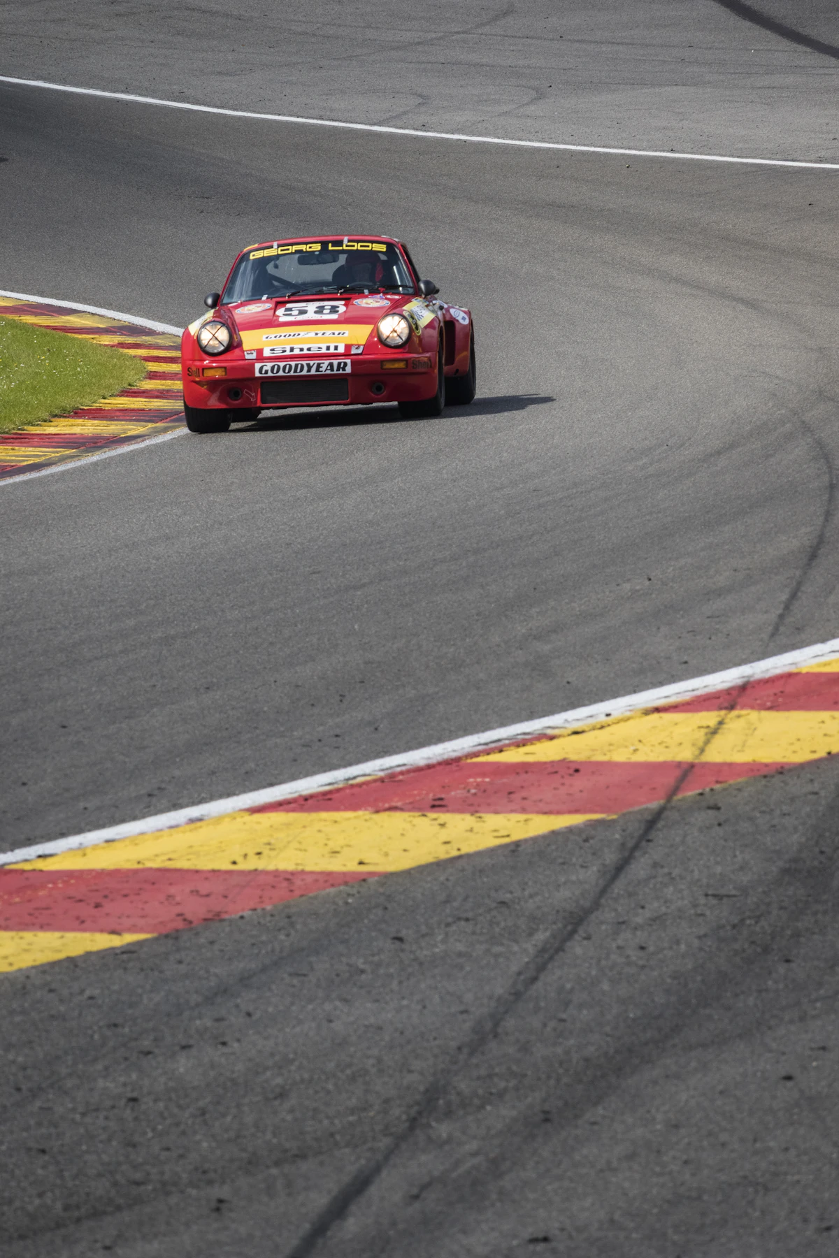 Coche deportivo rojo trazando una curva en un circuito