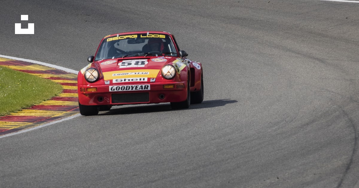 A red car driving down a race track photo – Free Belgique Image on Unsplash