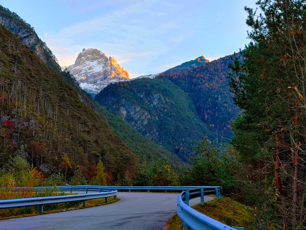 a winding road with a mountain in the background