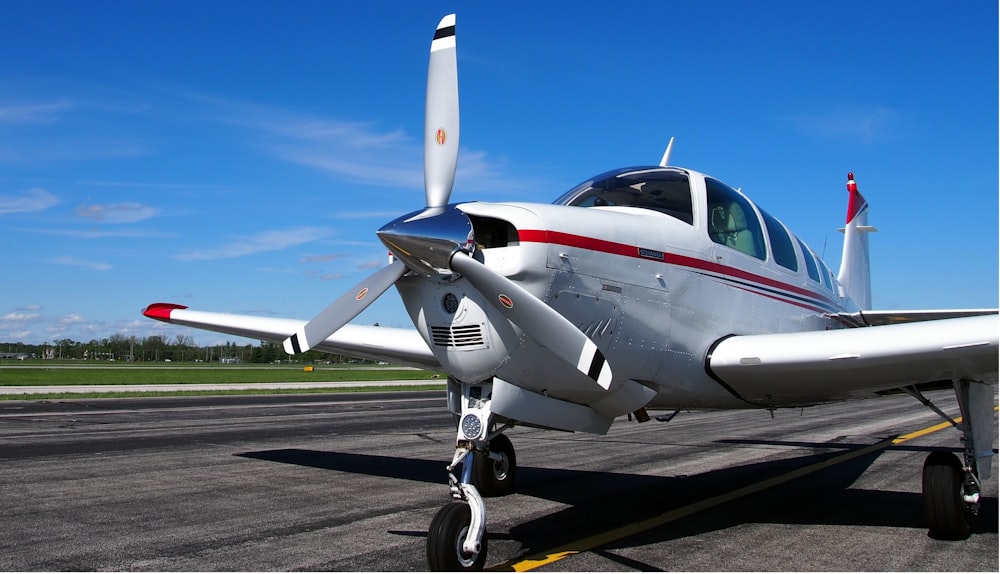 un petit avion assis au sommet d’une piste d’aéroport