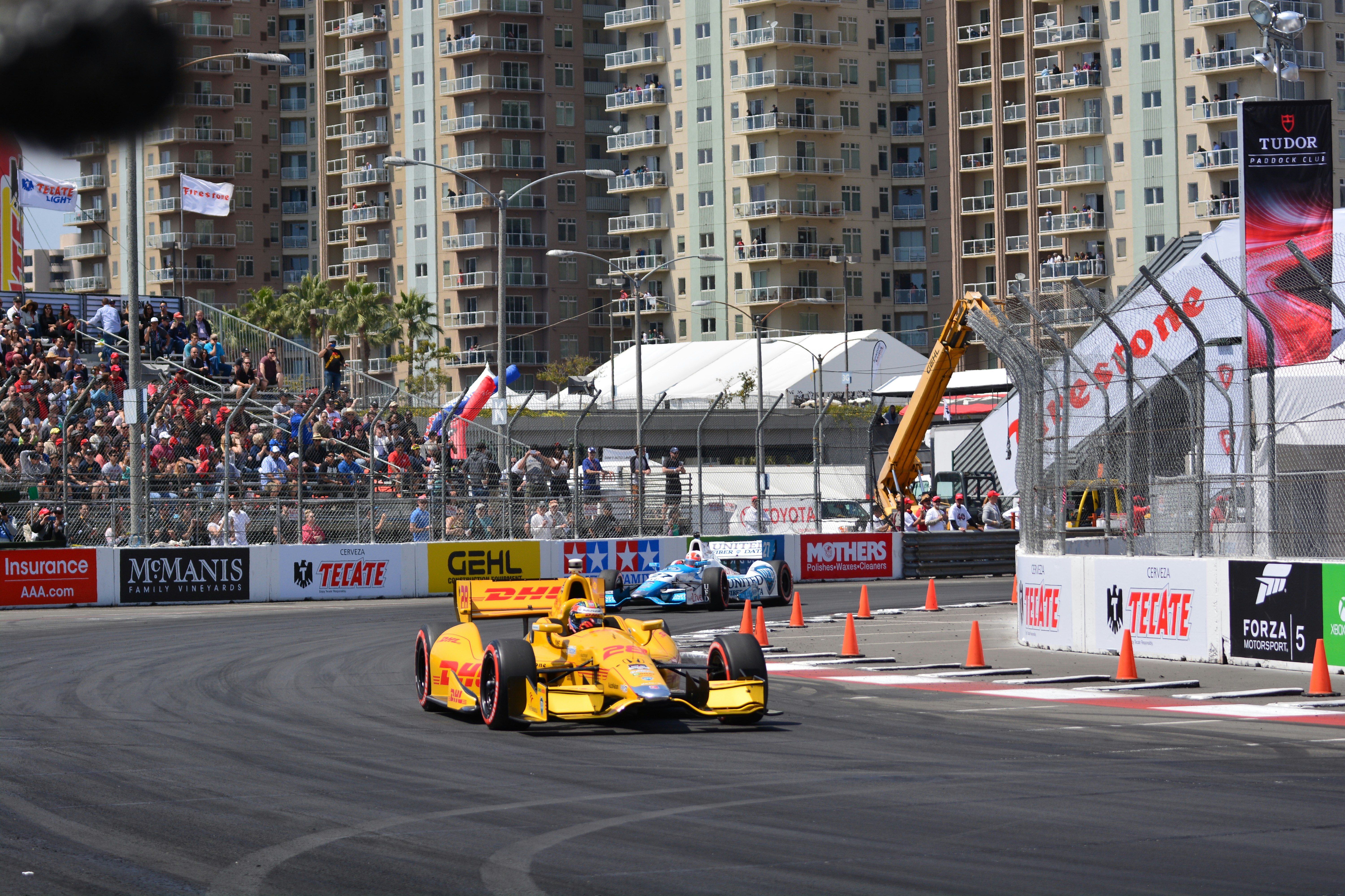 a yellow race car driving down a race track, Long Beach Grand Prix