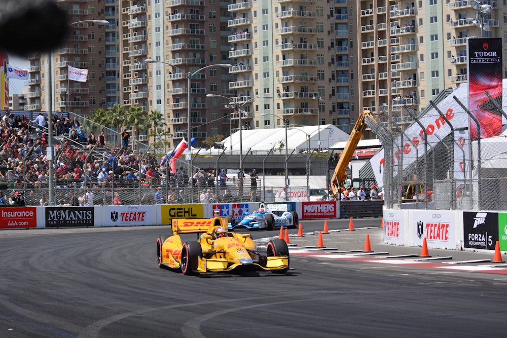 a yellow race car driving down a race track