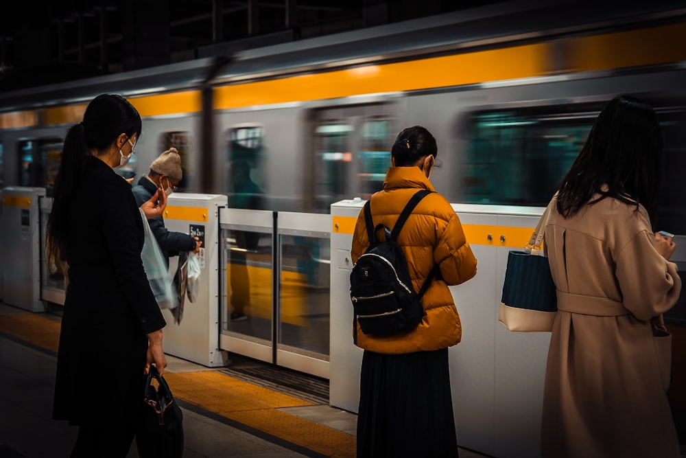 a group of people standing next to a train