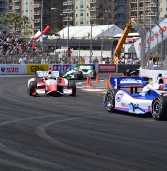 a group of racing cars driving down a race track