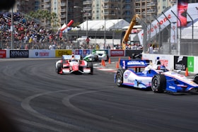 a group of racing cars driving down a race track