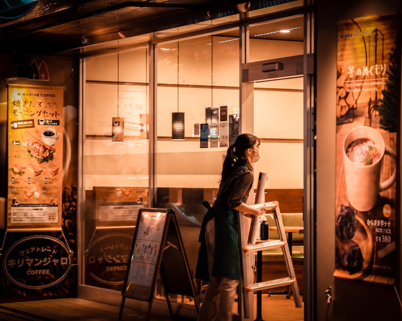 photo of a woman closing a coffee shop at night