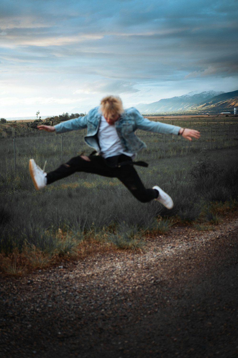 a person jumping in the air on a dirt road