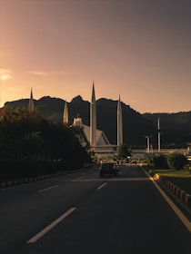 a car driving down a street next to a tall building