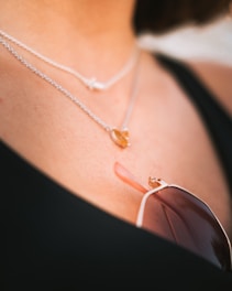 a close up of a woman wearing a necklace and sunglasses