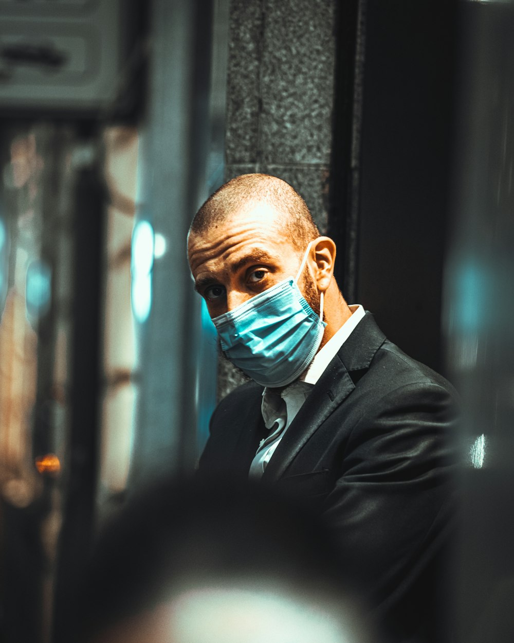 a man in a suit and a face mask