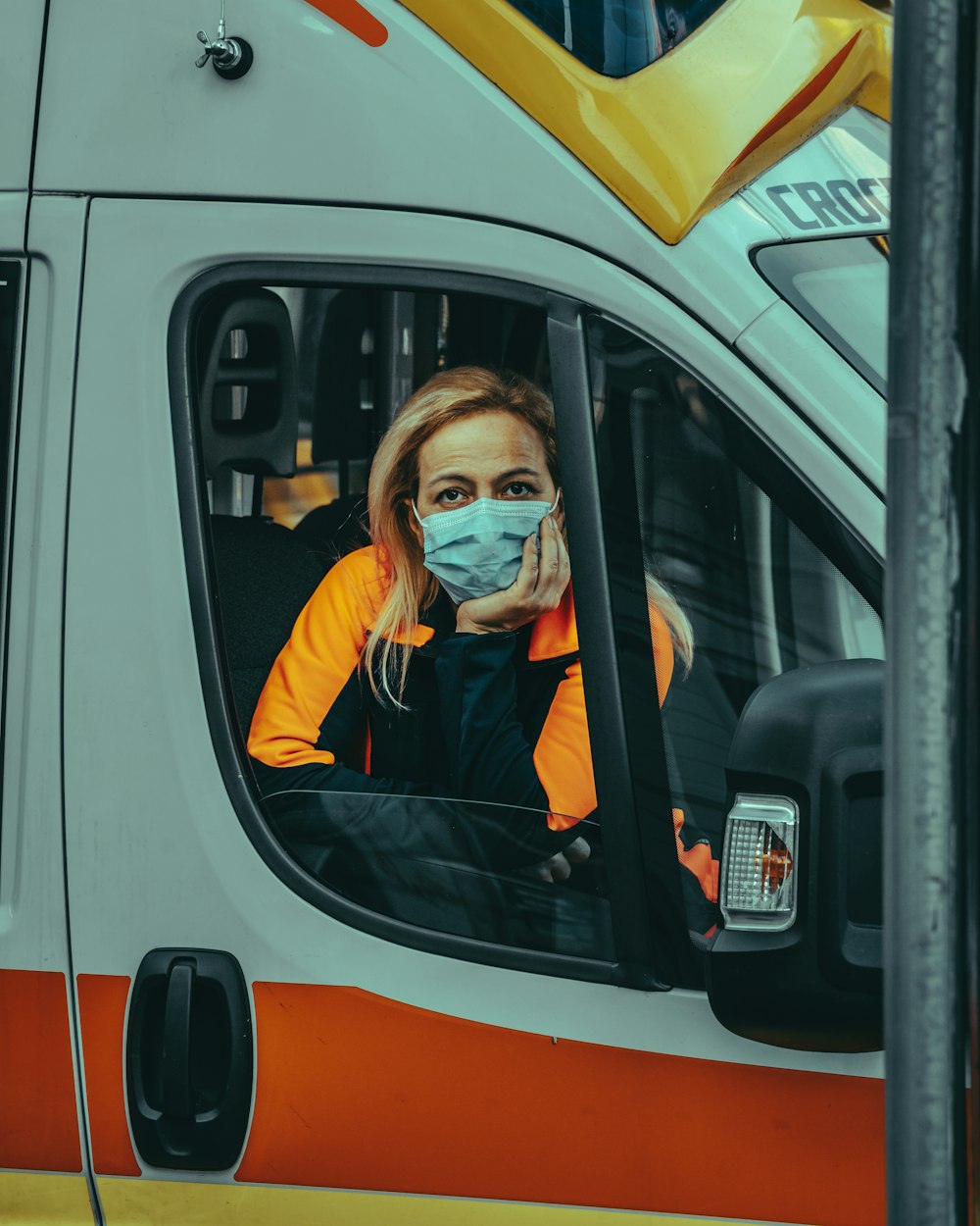 a woman wearing a face mask sitting in a bus