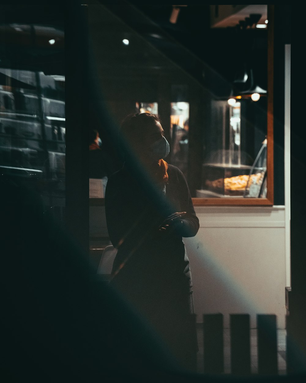 a woman standing in front of a window at night