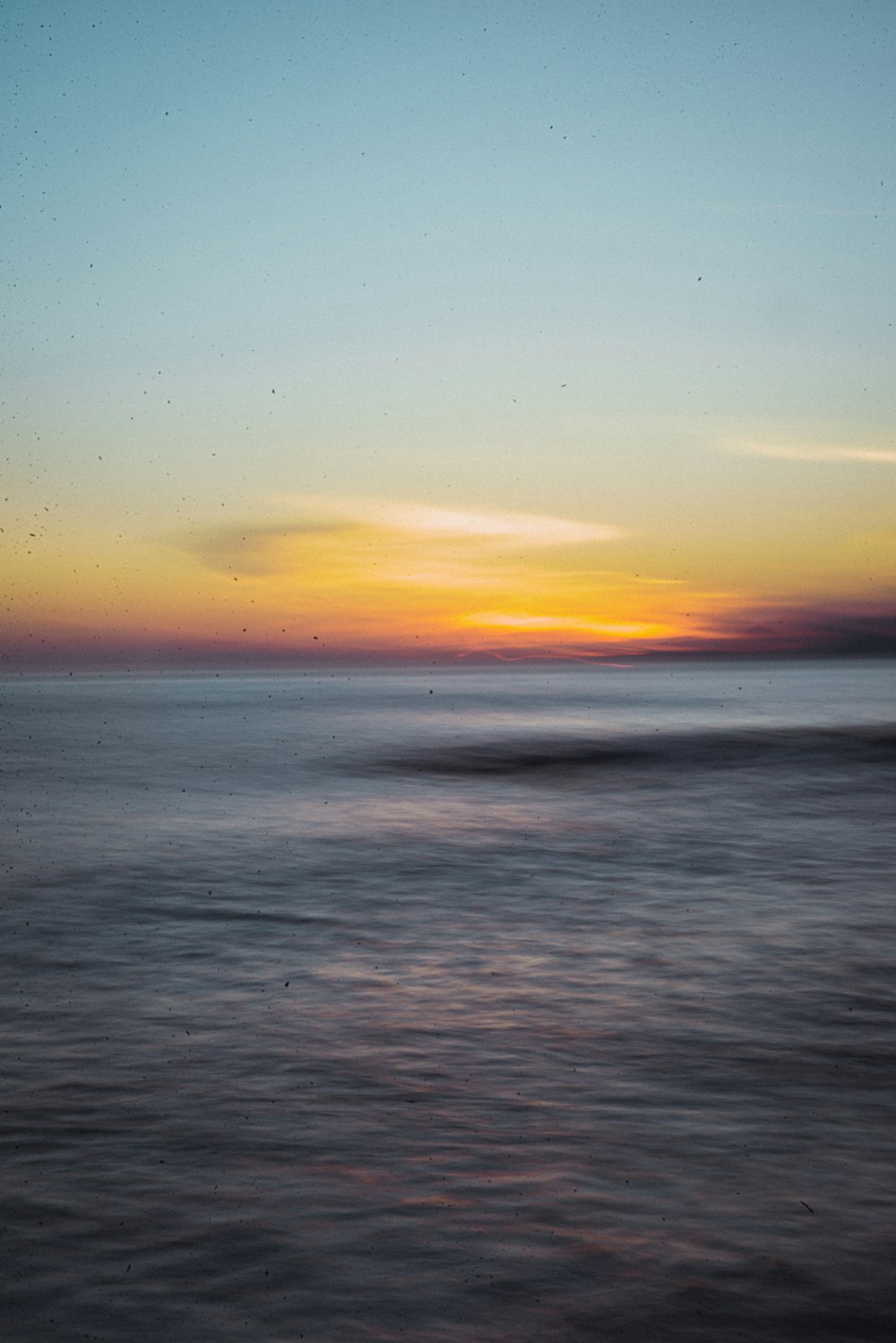 Il sole sta tramontando sull'oceano con le onde