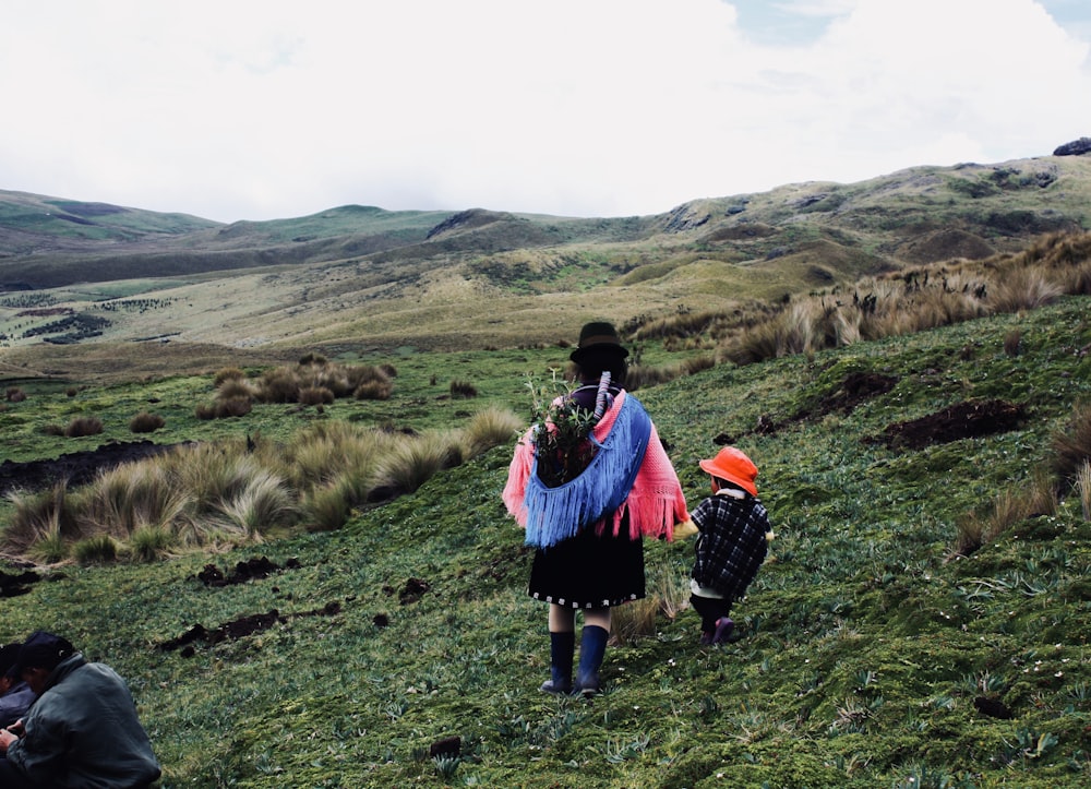 two people walking up a hill with a scarf