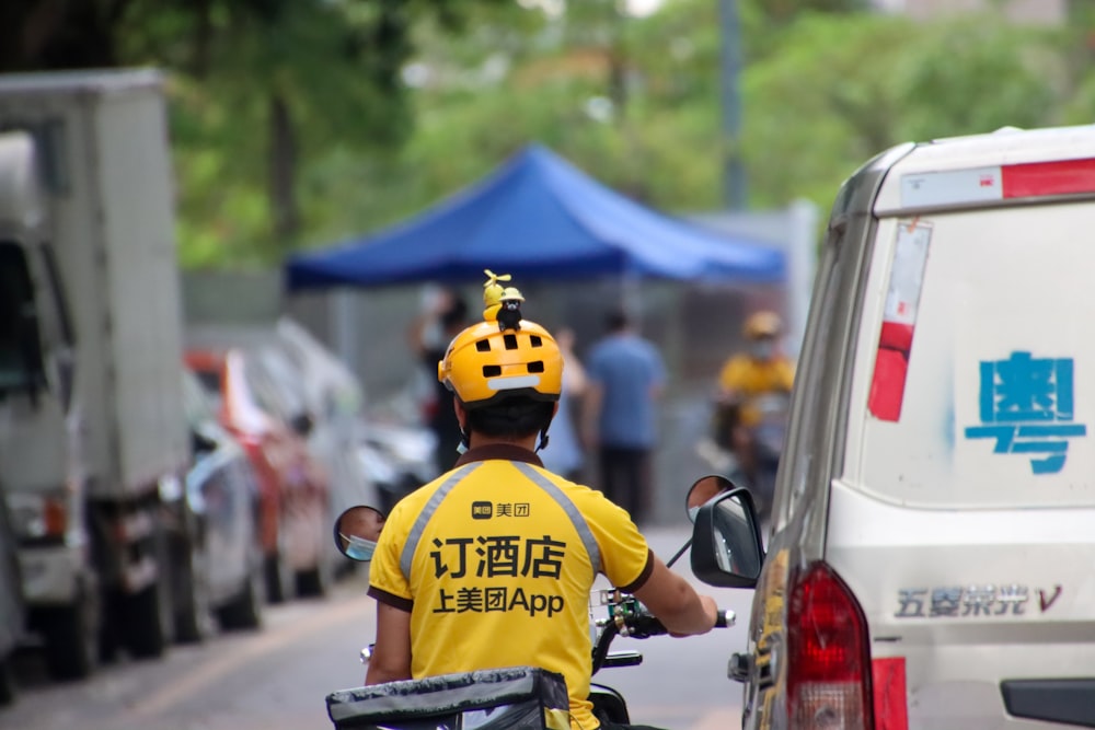 a man riding a bike down a street next to a van