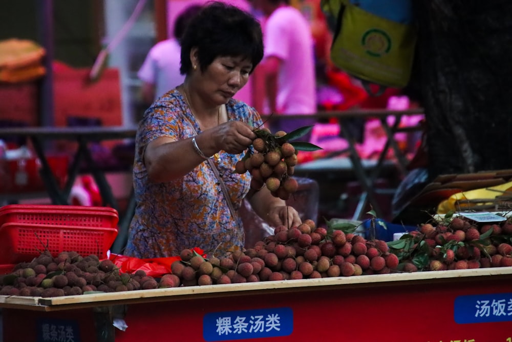 a woman standing in front of a fruit stand