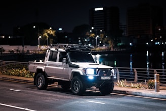 a white truck driving down a street at night