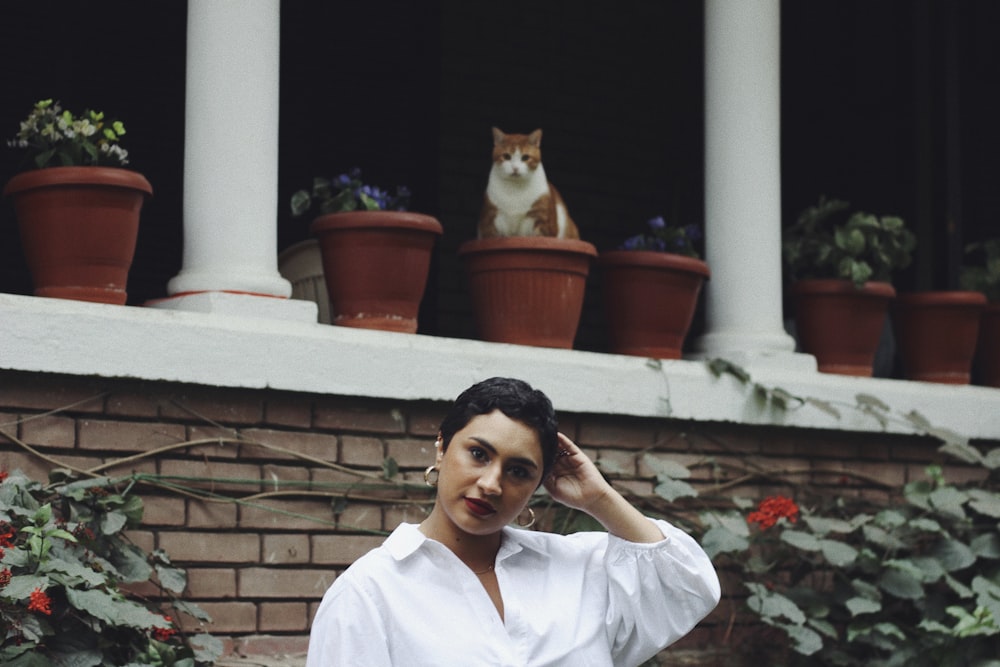 a woman standing in front of a brick building