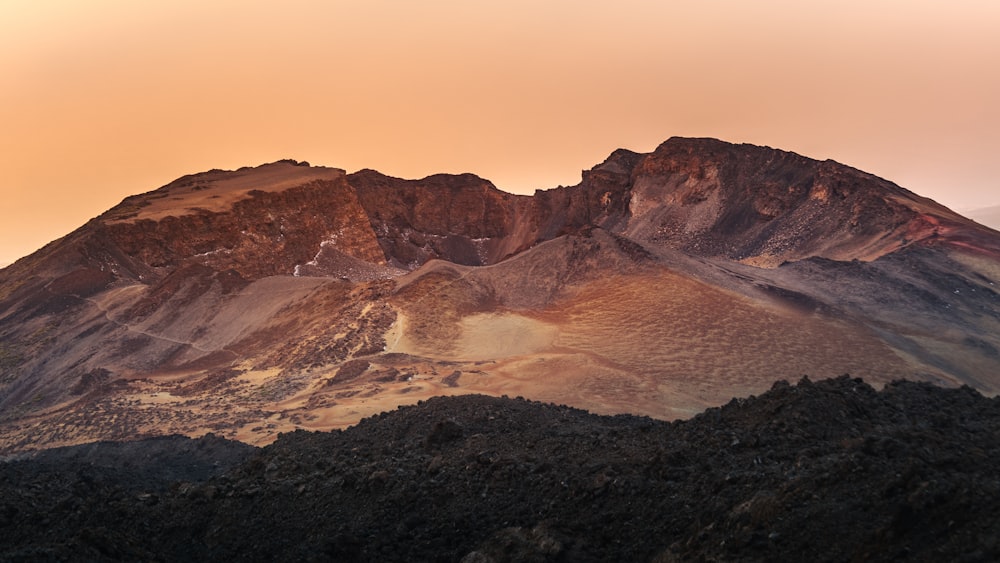 a mountain range with a bird flying over it