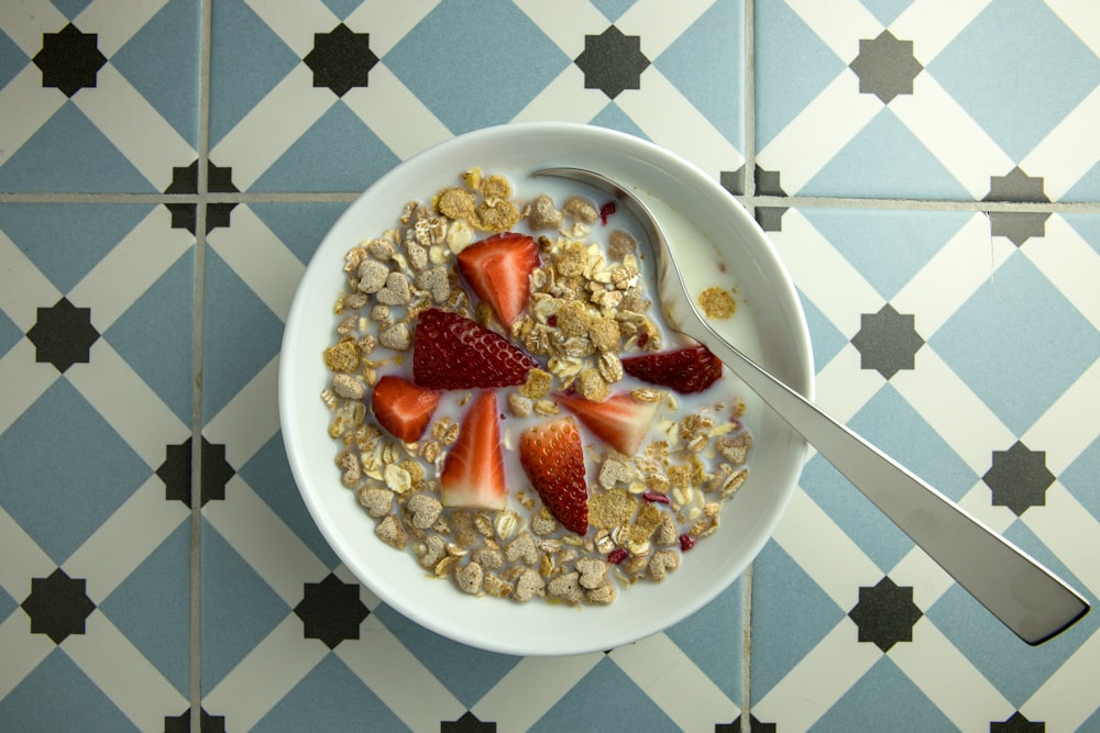 uma tigela de granola com morangos e iogurte