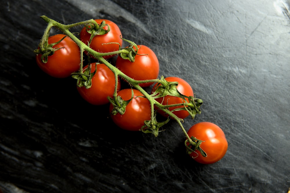 Ein Haufen Tomaten sitzt auf einer schwarzen Theke