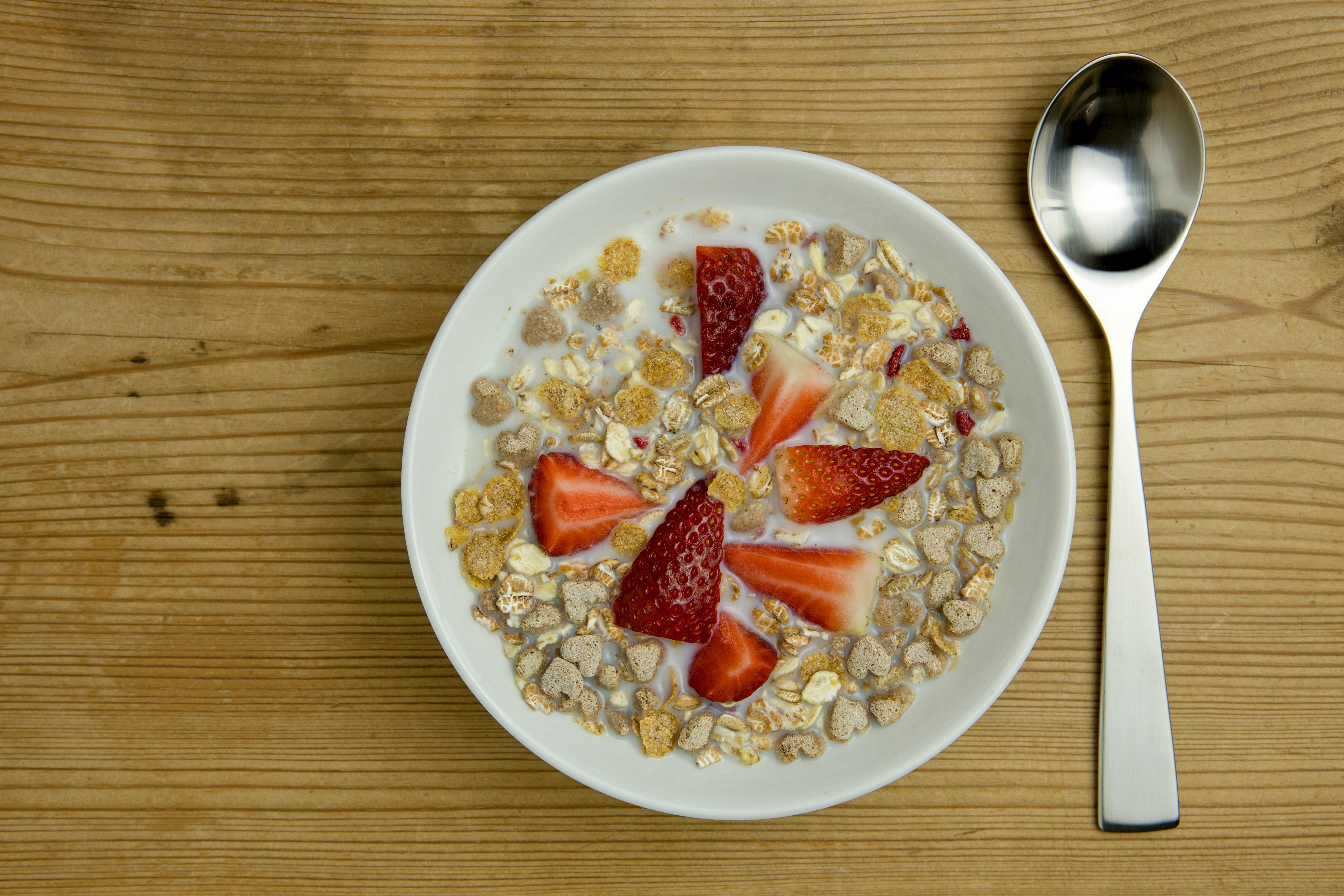a bowl of oatmeal with strawberries and granola, 